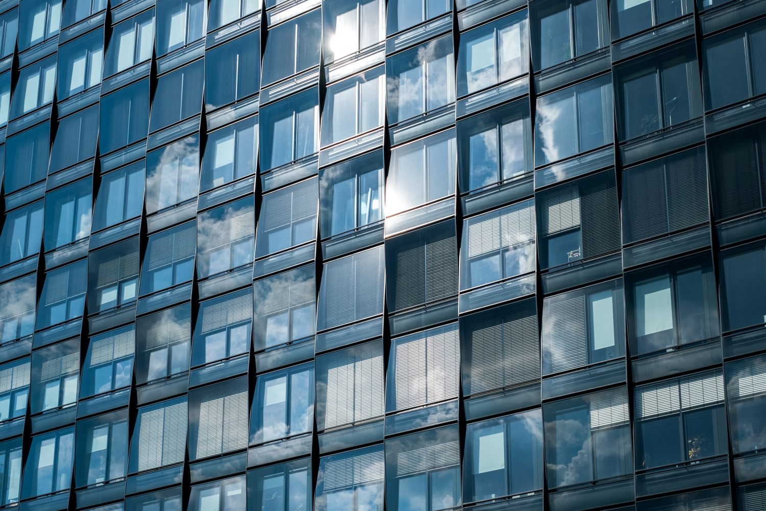A modern building facade with windows reflecting the sky